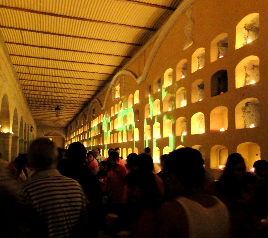Night scene with candles illuminating a wall of tombs at the main cemetery in the city of Oaxaca.