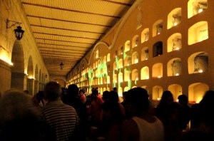 Night scene with candles illuminating a wall of tombs at the main cemetery in the city of Oaxaca.