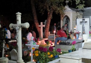 Night scene of family at a grave site in the main cemetery of the city of Oaxaca.