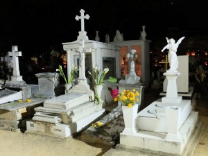 Night scene of monuments decorated with bouquets of marigolds and lillies in the main cemetery in the city of Oaxaca.