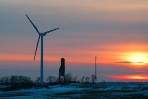 Wind turbine and old grain elevator at sunset