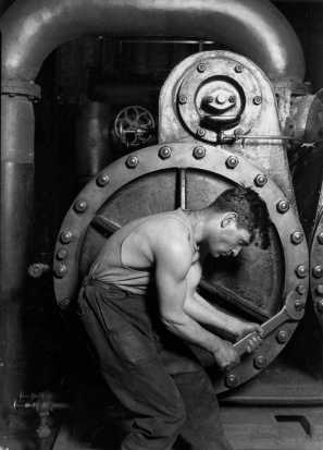 Male worker tighening bolts on a large boiler-like device.